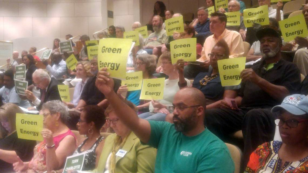 Charlotte citizens hold Green Energy signs